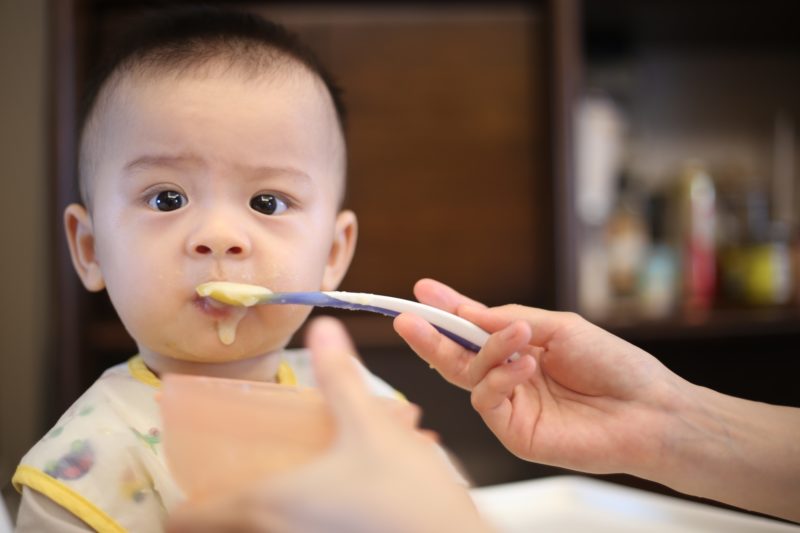 A baby being fed with a spoon