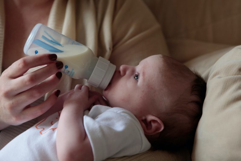 Baby being fed with milk bottle